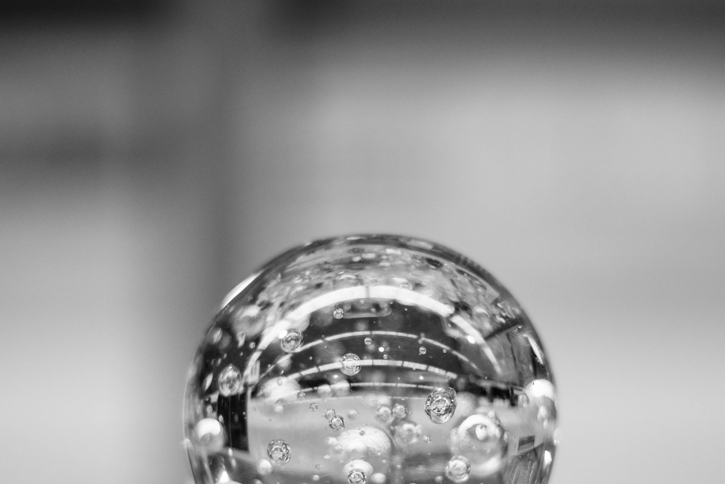 a glass ball sitting on top of a table, a macro photograph, by Jan Rustem, unsplash, black and white artistic photo, water particules, no blur dof bokeh, crystall