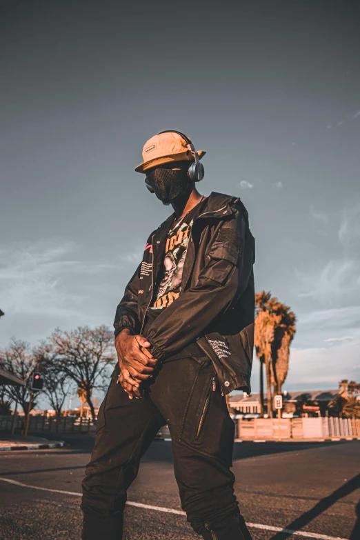 a man standing on the side of a road, trending on pexels, afrofuturism, finely masked, wearing a bomber jacket, wearing a backwards baseball cap, desertpunk