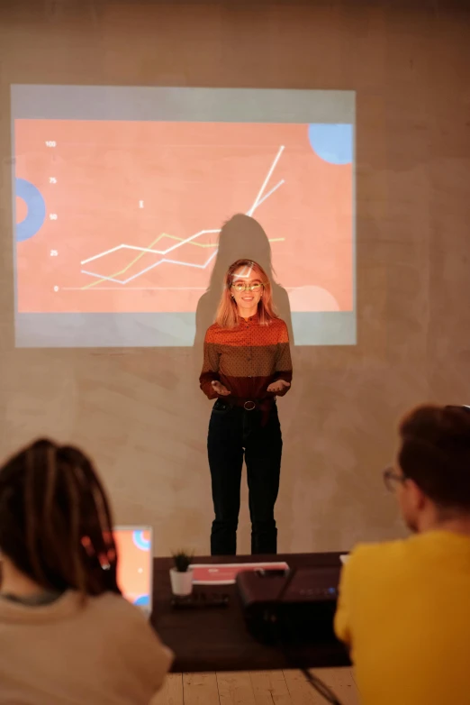 a woman standing in front of a projector screen, trending on unsplash, academic art, graphs, in a workshop, performance, promo image