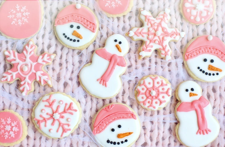 a bunch of decorated cookies sitting on top of a table, snow on the body, light pink tonalities, frosty, upper body close up