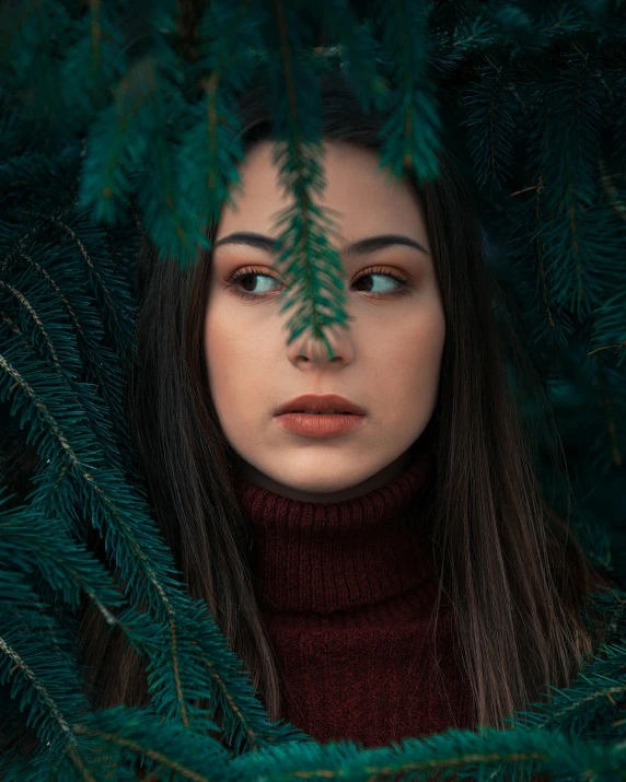 a woman is hiding in the branches of a tree, a character portrait, inspired by Elsa Bleda, trending on pexels, wearing turtleneck, dark green eyes, brunette woman, green and red