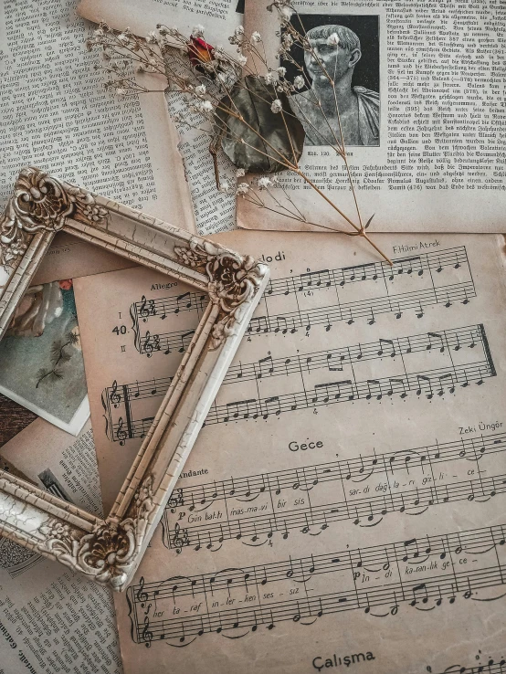 a picture frame sitting on top of a sheet of music, by Lucia Peka, pexels contest winner, neoclassicism, square pictureframes, scratches on photo, ivory rococo, 15081959 21121991 01012000 4k