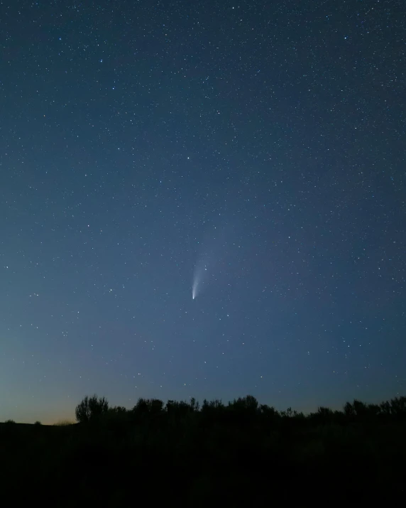 a sky filled with lots of stars next to a forest, comet, rocket launch, instagram picture, blue