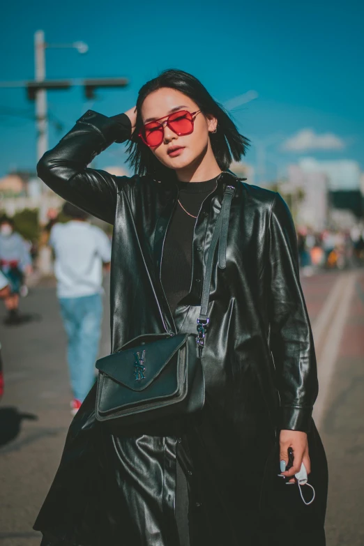 a woman wearing a black leather coat and red sunglasses, a picture, trending on pexels, mai anh tran, street wear, instagram photo, festival vibes