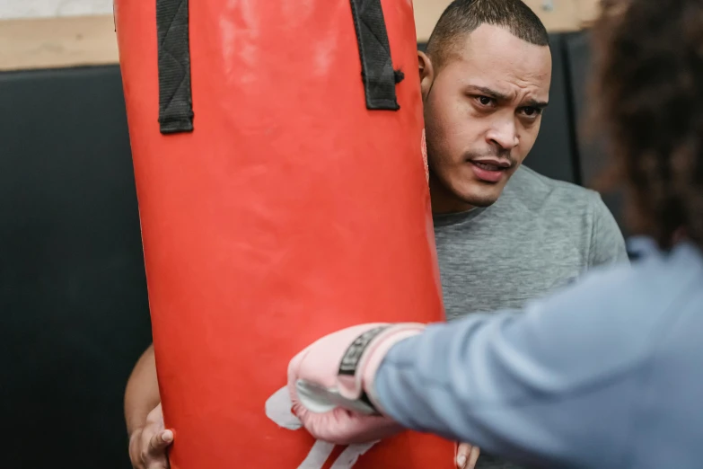 a man standing next to a punching bag, pexels contest winner, hands shielding face, manuka, profile image, background image