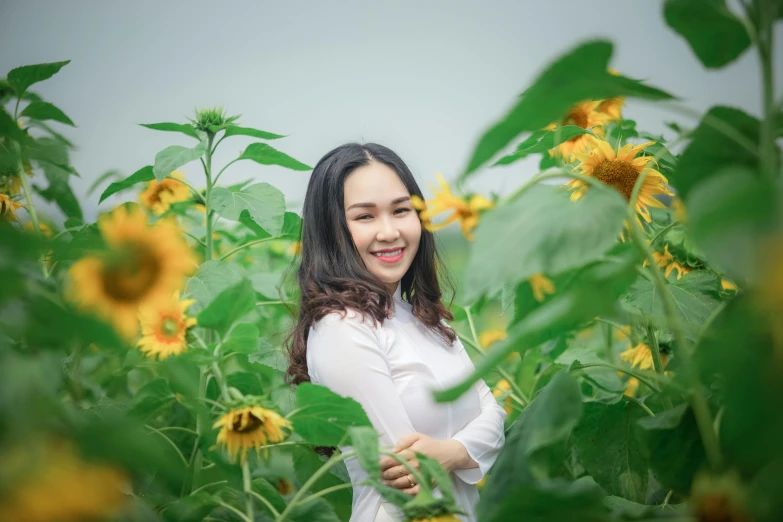 a woman standing in a field of sunflowers, inspired by Ruth Jên, pexels contest winner, ao dai, avatar image, white, full frame image