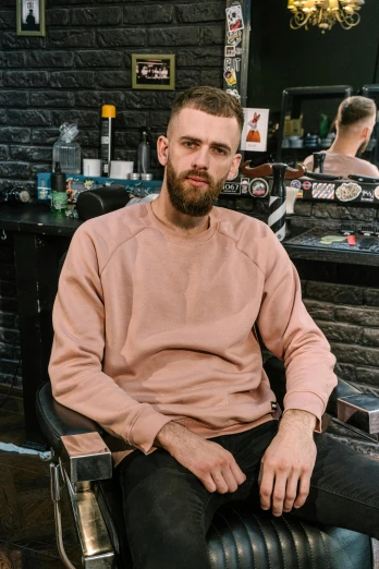 a man sitting in a chair in a barber shop, a character portrait, inspired by Jóhannes Sveinsson Kjarval, trending on reddit, wearing sweatshirt, stubble beard, lil peep, commercial photo