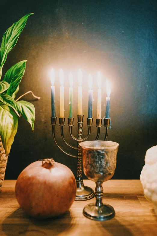 a bunch of candles sitting on top of a wooden table, a still life, trending on unsplash, sukkot, ornamental halo, blue and gold color scheme, charcoal and silver color scheme