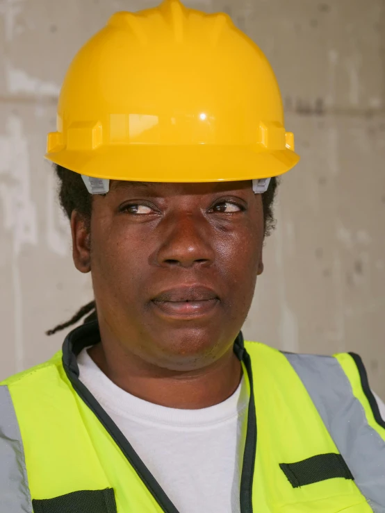 a woman wearing a hard hat and safety vest, by Jan Gregoor, young thug, androgynous face, high resolution photo, transgender