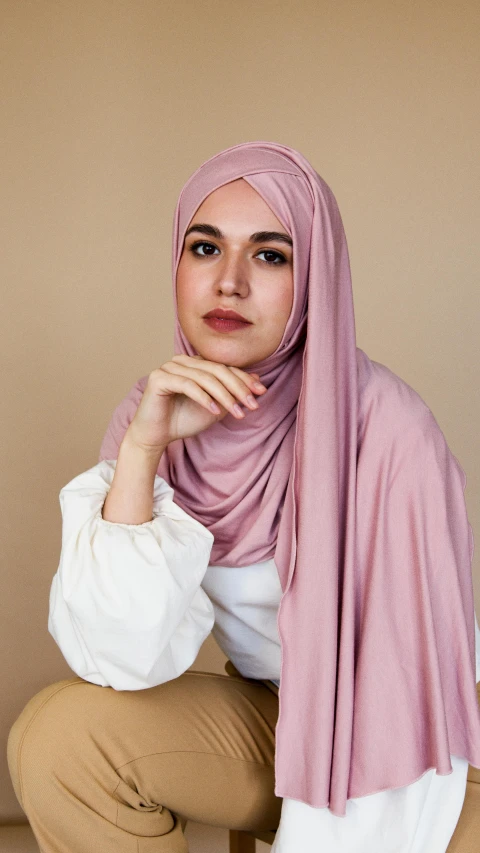 a woman in a hijab poses for a picture, an album cover, trending on pexels, hurufiyya, pastel pink skin tone, 6 k, photographed for reuters, 15081959 21121991 01012000 4k