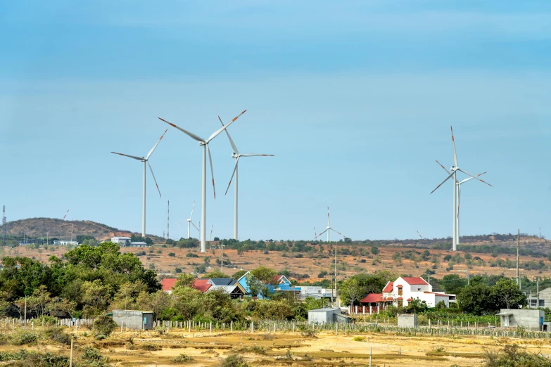 a group of windmills in a field with houses in the background, pexels contest winner, hurufiyya, wired landscape, a green, in chuquicamata, profile image