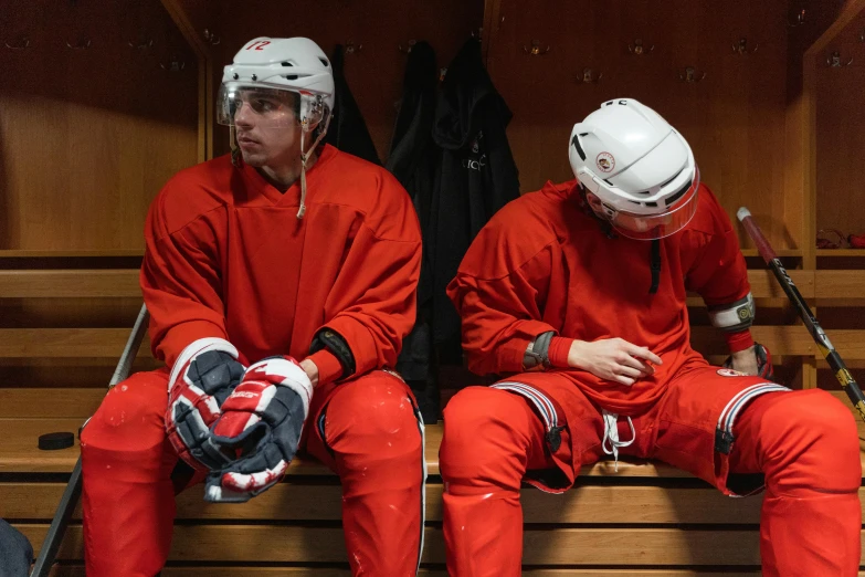 a couple of men sitting next to each other in a locker, by Jaakko Mattila, shutterstock, full ice hockey goalie gear, red sweatband, sit on a bench, pictured from the shoulders up