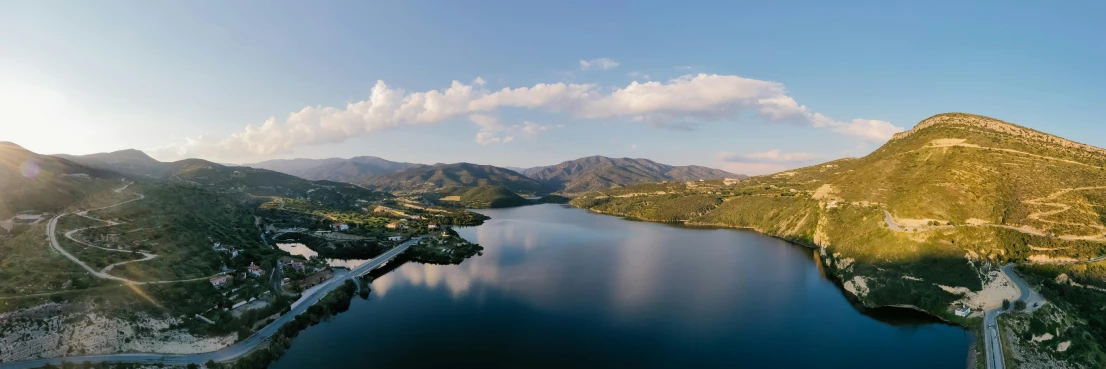 a large body of water surrounded by mountains, by Lee Loughridge, pexels contest winner, hurufiyya, aerial footage, panorama view, loomis, mid morning lighting