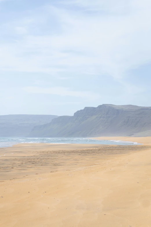 a man riding a horse on top of a sandy beach, by Hallsteinn Sigurðsson, les nabis, seen from afar, moroccan, serene beach setting, coastal cliffs