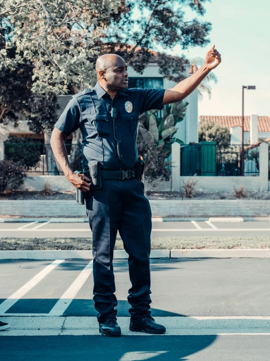 a man in a police uniform standing in a parking lot, pexels contest winner, shrugging, los angeles ca, profile image, ( ( theatrical ) )