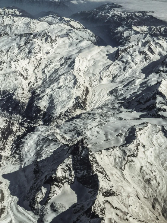 an aerial view of a snow covered mountain range, by Matthias Weischer, fan favorite, alessio albi, high detailed photo