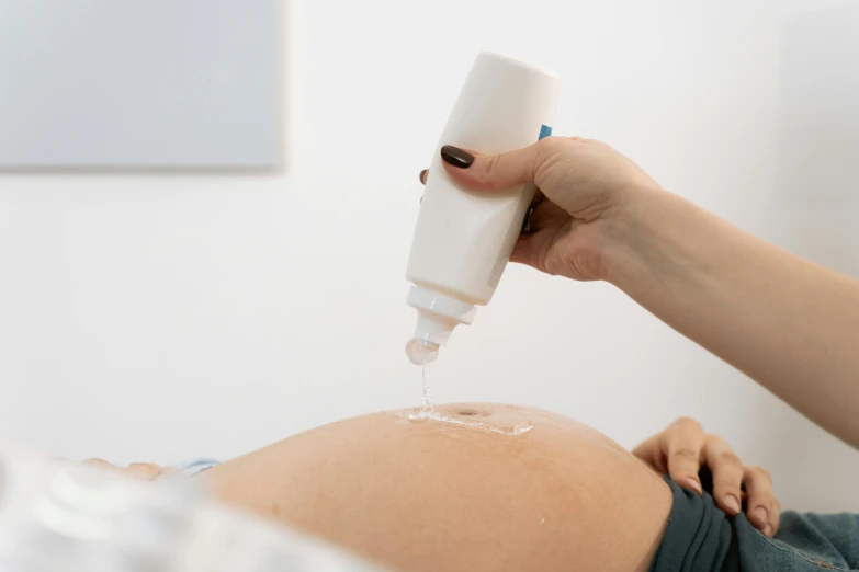 a close up of a person holding a bottle of liquid, by Évariste Vital Luminais, trending on pexels, figuration libre, pregnant belly, iv pole, straya, bump mapping