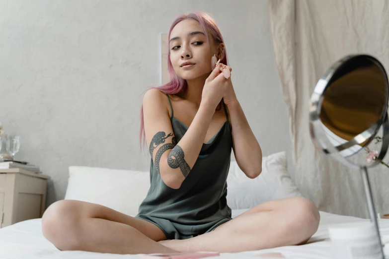 a woman with pink hair sitting on a bed, a tattoo, inspired by Elsa Bleda, trending on pexels, smooth tan skin, korean woman, cute girl wearing tank suit, grey skin