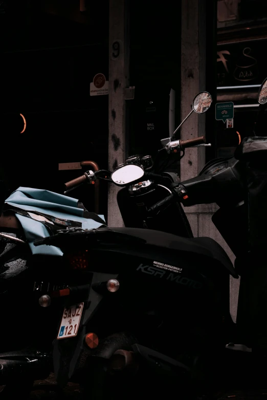 a motor scooter parked in front of a building, in the dark, riding a motorbike, in a workshop, blue and black