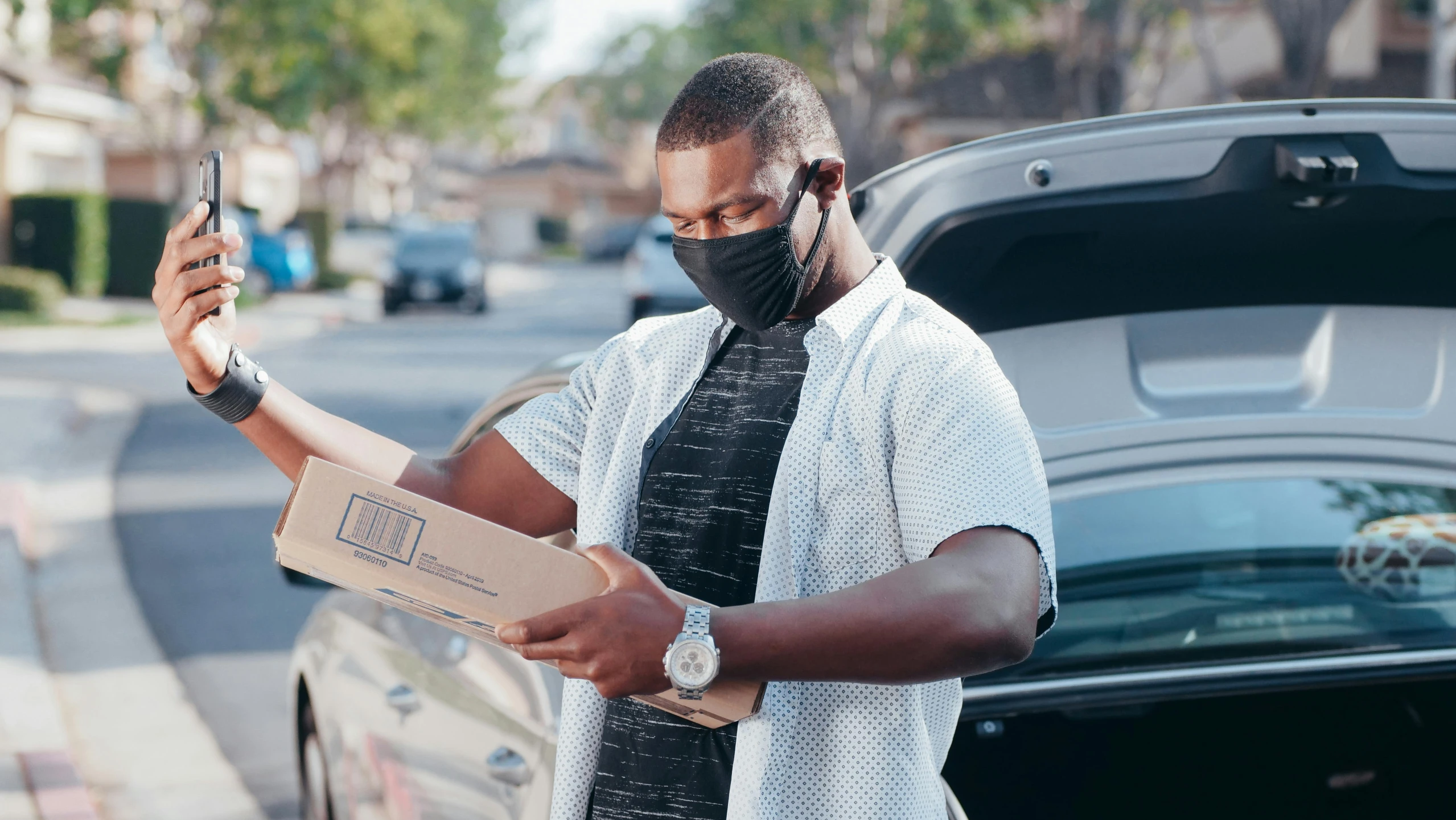 a man wearing a face mask and holding a cell phone, pexels contest winner, renaissance, delivering parsel box, mkbhd, cybertruck, cooked