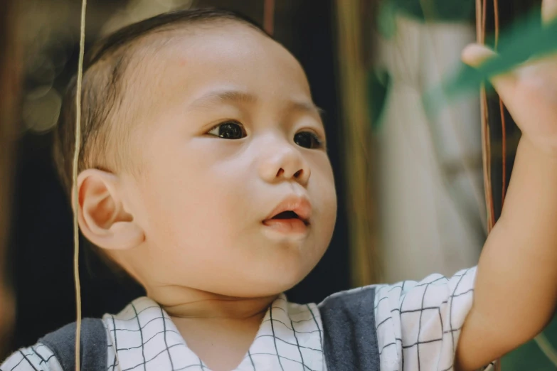 a close up of a baby looking up, pexels contest winner, asian male, looking her shoulder, high quality screenshot, with a kid