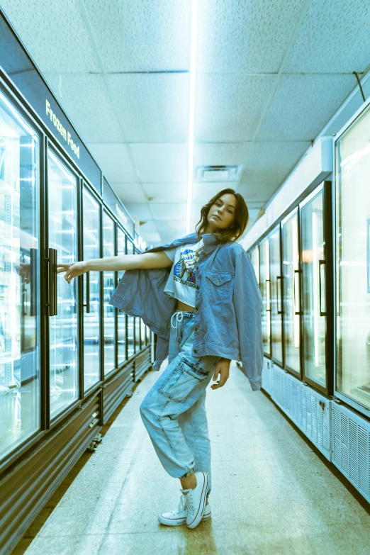 a woman standing in the middle of a long hallway, an album cover, inspired by Elsa Bleda, pexels, graffiti, stood in a supermarket, ice cold blue theme, isabela moner, hot food