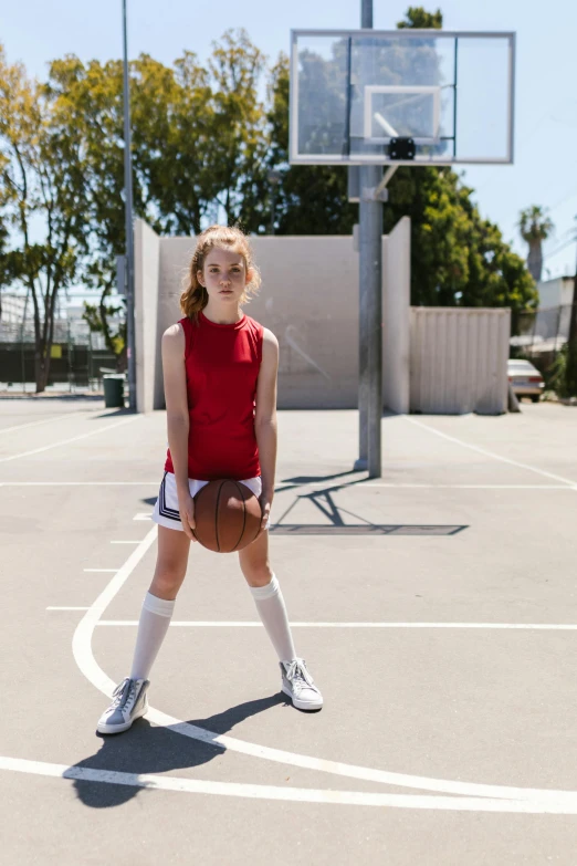 a young girl standing on top of a basketball court, by Gavin Hamilton, dribble contest winner, sophia lillis, red uniform, full product shot, shorts