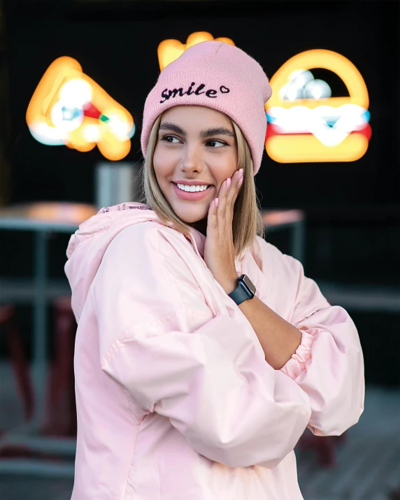 a woman in a pink jacket talking on a cell phone, featured on instagram, beanie, smiling :: attractive, light pink, press shot