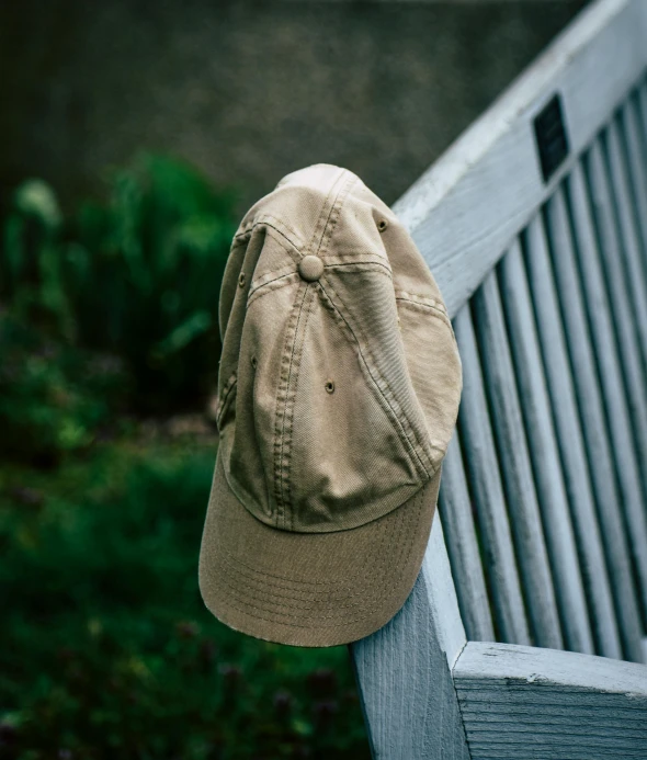 a hat sitting on top of a wooden bench, by Adam Chmielowski, lo-fi, baseball cap, light tan, well worn