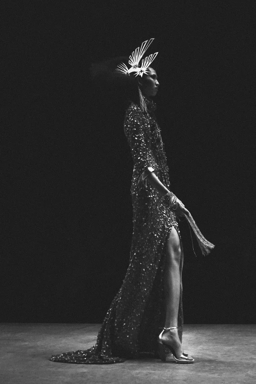 a black and white photo of a woman in a dress, an album cover, featured on cgsociety, glitter gif, slender figure, black haute couture, torch - lit