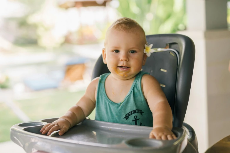 a baby is sitting in a high chair, a portrait, pexels contest winner, big island, confident looking, avatar image, vacation photo