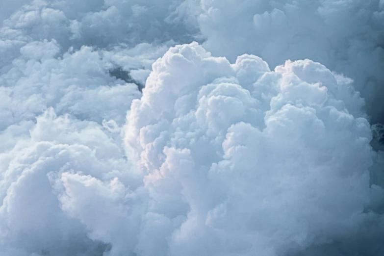 a plane flying through a cloud filled sky, an album cover, by Adam Marczyński, pexels contest winner, romanticism, cotton candy clouds, highly detailed close up shot, voluminous, grey