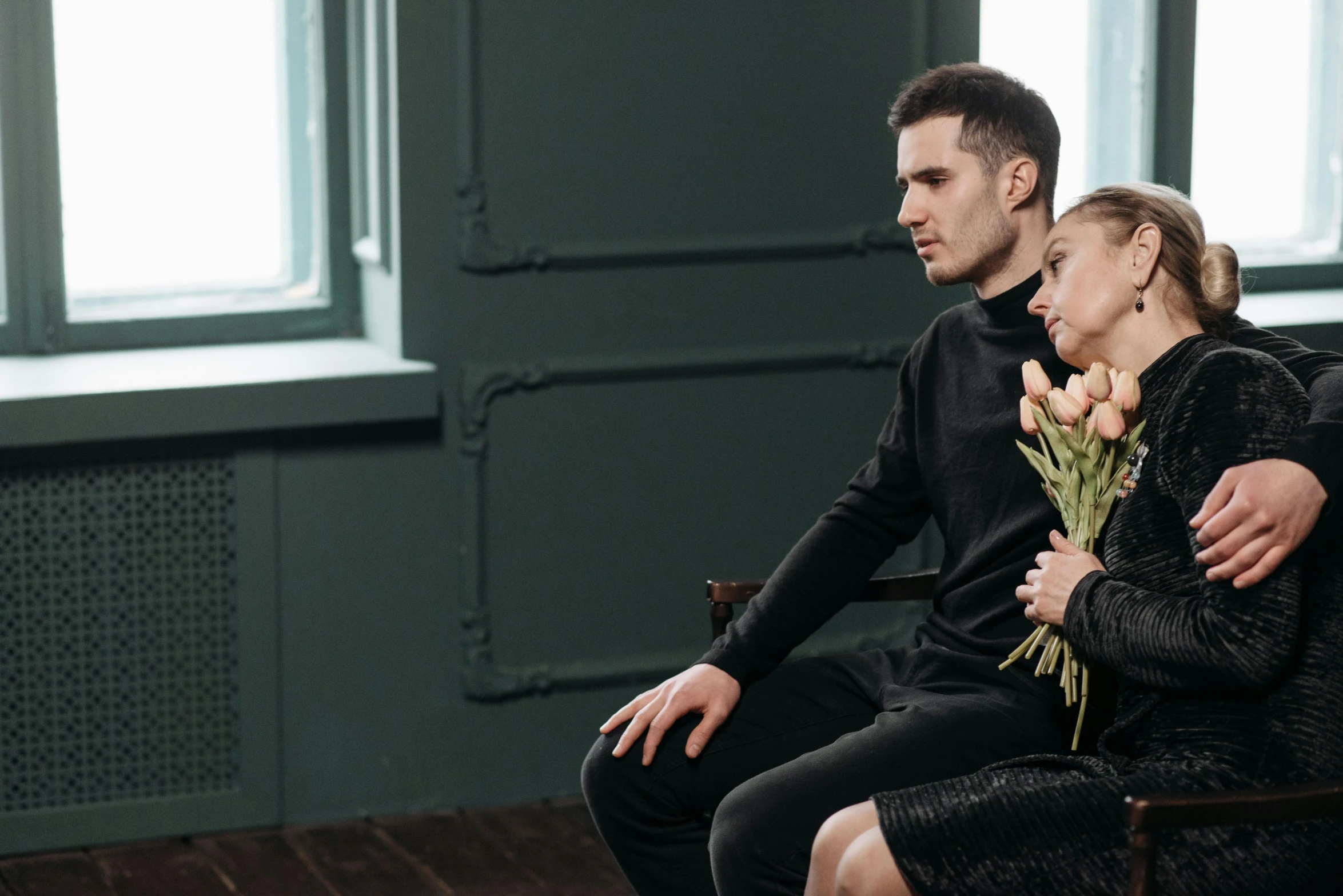 a man and a woman sitting next to each other, by Adam Marczyński, pexels contest winner, romanticism, black clothing, carrying flowers, two buddies sitting in a room, listing image