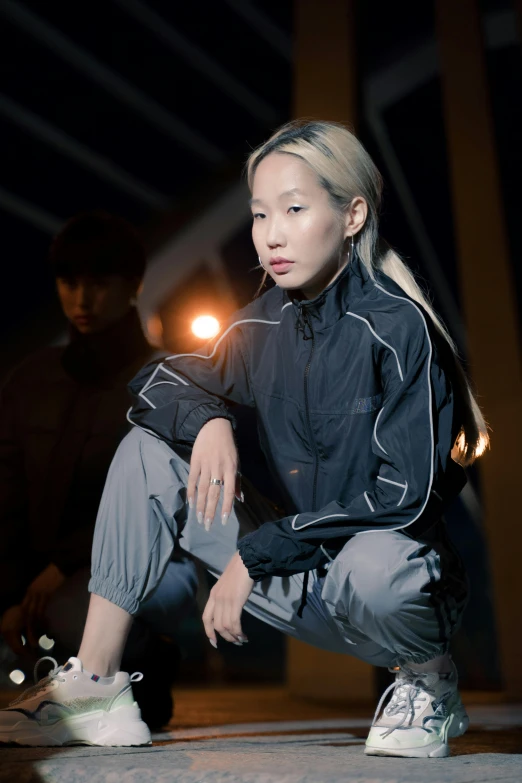 a woman kneeling on the ground with a skateboard, inspired by Wang E, wearing a track suit, dark lighting, jon kuo, tech wear