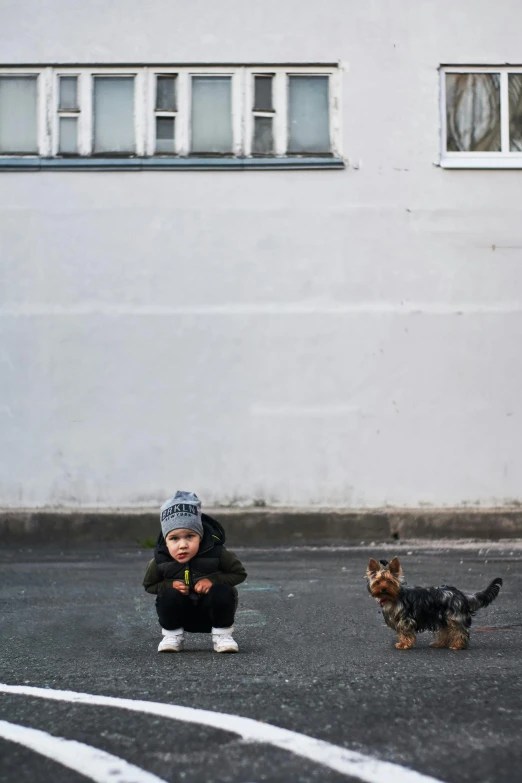 a small child and a small dog in a parking lot, pexels contest winner, minimalism, he also wears a grey beanie, dasha taran, square, boys