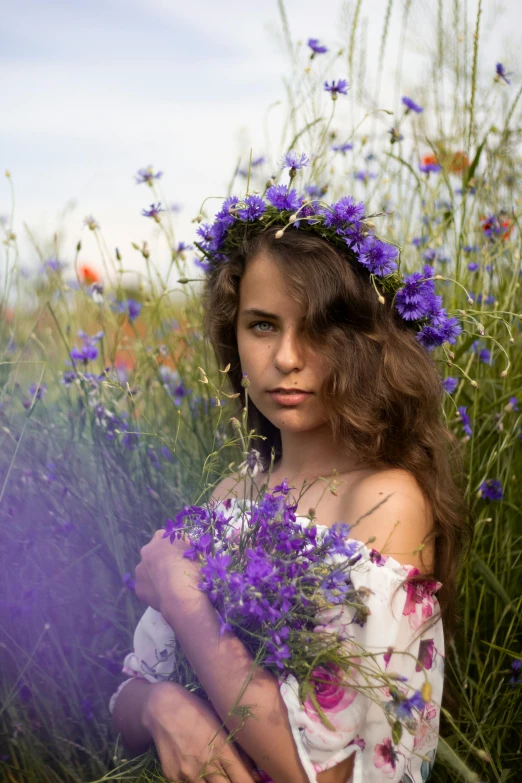 a woman sitting in a field of purple flowers, a colorized photo, by Adam Marczyński, pexels contest winner, renaissance, teen girl, crown of blue flowers, medium format, head shot