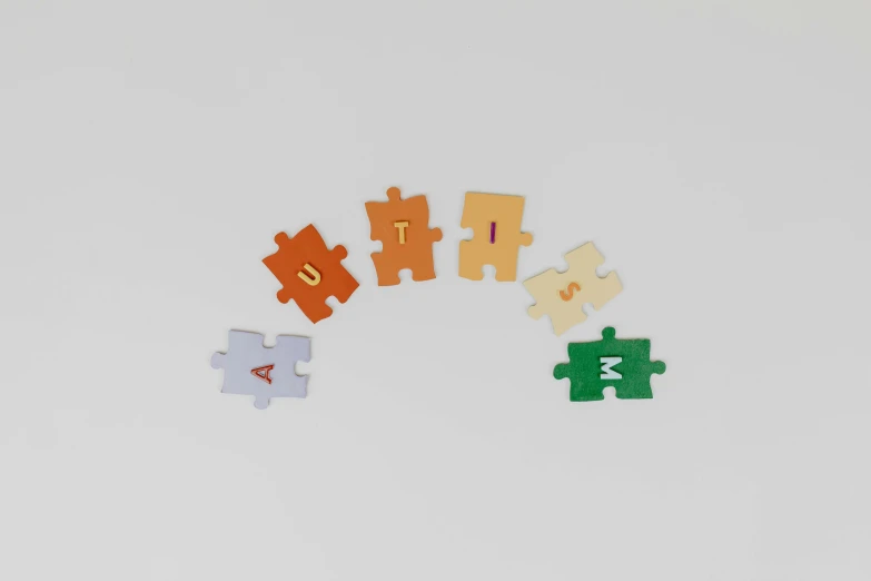 a group of pieces of puzzle sitting on top of a table, a jigsaw puzzle, by Jessie Algie, letterism, product render, rainbow colours, aum, autumnal