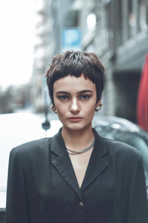 a woman standing in the middle of a city street, an album cover, inspired by Elsa Bleda, trending on pexels, renaissance, pixie undercut short black hair, symmetrical vogue face portrait, headshot profile picture, maxim sukharev