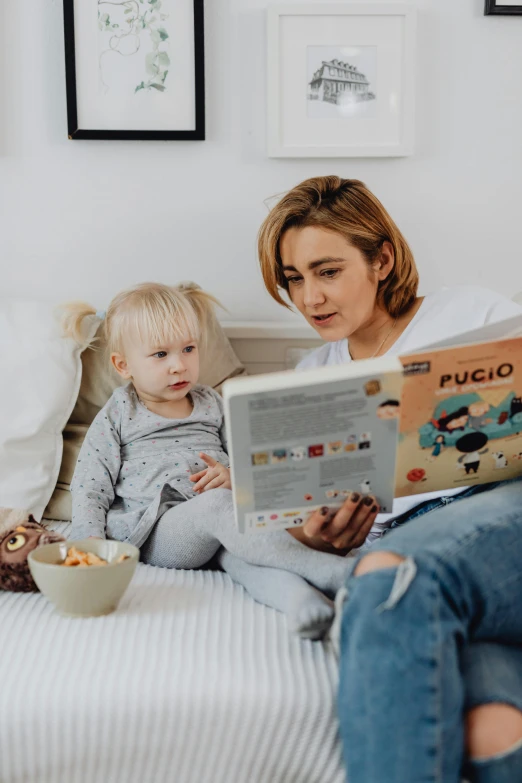 a woman reading a book to a child on a bed, by Lucia Peka, pexels contest winner, looking to the right, product introduction photo, photo in style of paola kudacki, multi-part