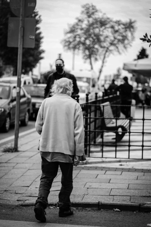 a black and white photo of a man walking down the street, a black and white photo, happening, an old lady, stand off, faceless, older male