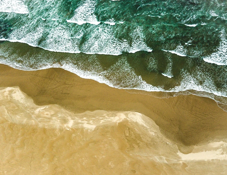 a person riding a surfboard on top of a sandy beach, inspired by Andreas Gursky, helicopter view, erosion, wallpapers, ochre