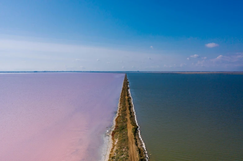 a large body of water next to a beach, by Brad Holland, unsplash contest winner, land art, pink power, joel sternfeld, lake blue, over the horizon