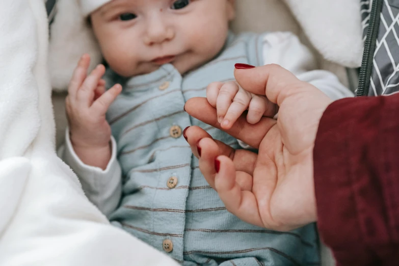 a close up of a person holding a baby, with fingers, looking cute, very consistent, instagram photo