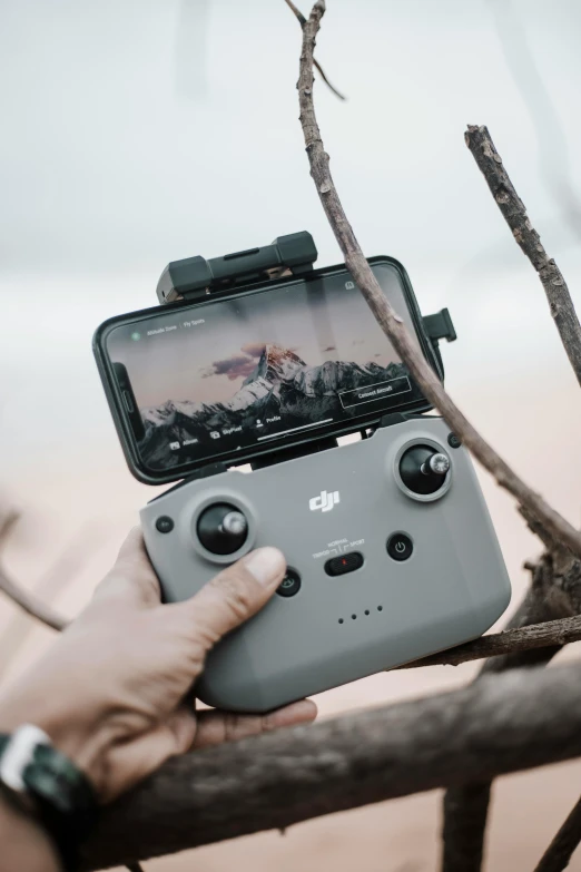 a person holding a video game controller in their hand, dji top down view, trail camera, grey, music video