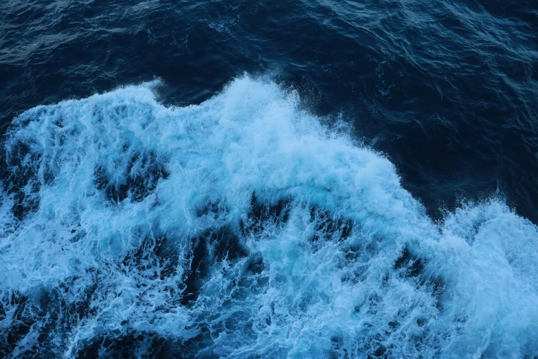 a large body of water with waves coming out of it, an album cover, pexels, hurufiyya, deep blue sea color, thumbnail, a high angle shot, the sea of sadness