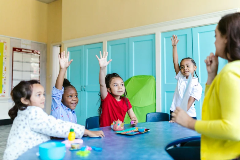 a group of children sitting at a table with their hands in the air, by Arabella Rankin, pexels contest winner, educational supplies, avatar image, 15081959 21121991 01012000 4k, alexis franklin