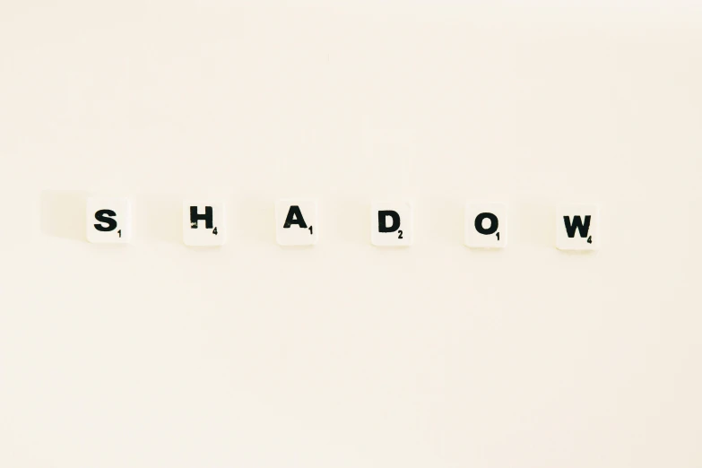 the word shadow spelled in scrabbles on a white surface, an album cover, by Andrew Domachowski, trending on pixabay, dada, 🪔 🎨;🌞🌄, crawling out of a dark room, on a pale background, got shut down