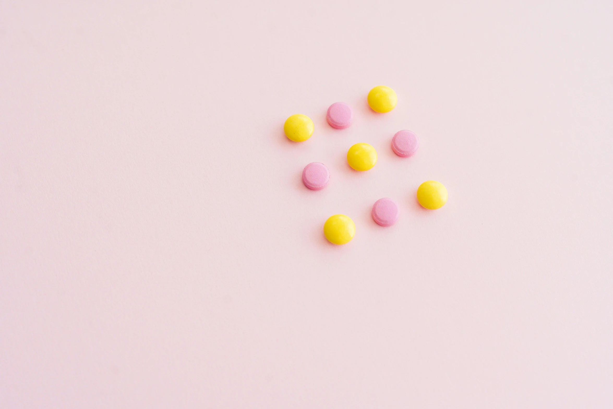 pink and yellow pills scattered on a pink surface, by Emma Andijewska, antipodeans, dividing it into nine quarters, made of candy, minimalissimo, studs