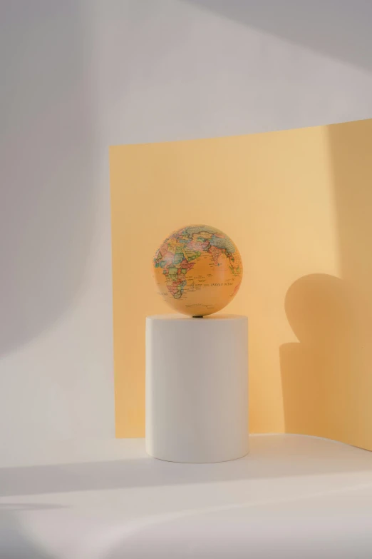 a globe sitting on top of a white pedestal, orange pastel colors, detailed product image, light mode, archviz