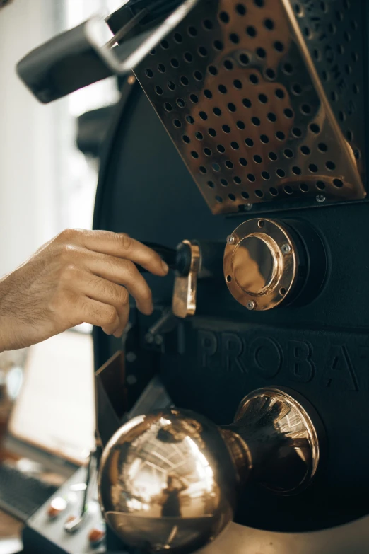 a close up of a person using a coffee grinder, by Matthias Stom, brass and steam technology, thumbnail, panel, jovana rikalo